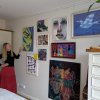 Woman admiring eclectic home gallery wall hung on clear perlon wires from ArtiTeq Click Rail picture rail