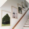 photos hanging in stairway with sloped walls