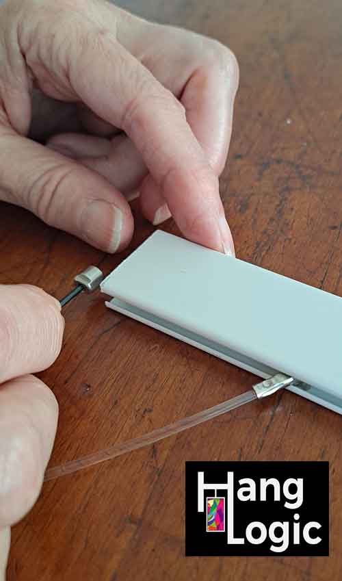 Close-up of hands using an Allen key to slide a stopper into a rail to secure the solid slider.