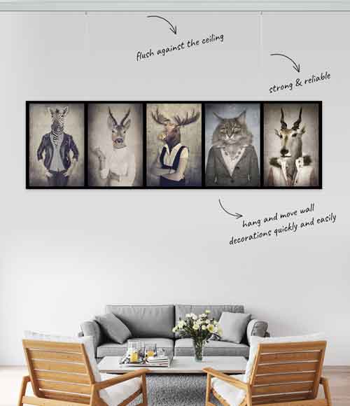 Living room with sofa and framed animal portraits hanging using Artiteq picture rail system. Available at Hang Logic.
