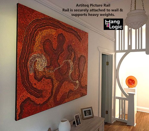 Interior room featuring an Artiteq Picture Rail securely holding a large, heavy Aboriginal artwork above a decorative setup.