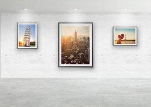 Modern gallery with framed photos hanged on rails against a masonry wall - available at Hang Logic.