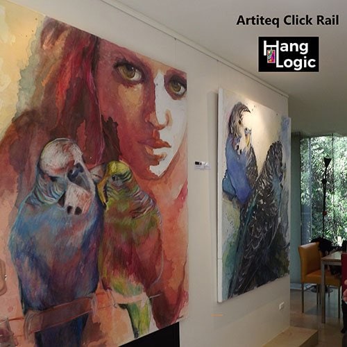 Hang Logic Artiteq Click Rail system supports a colorful art gallery wall featuring an array of paintings."