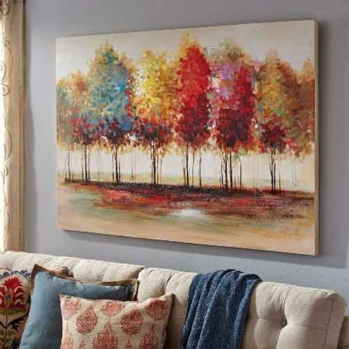 Autumn Trees Artwork Colourful autumn trees artwork hanging on a wall, above a sofa with cushions.