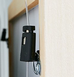 Close-up of a 1mm Micro Grip hook attached to a picture hanging wire.