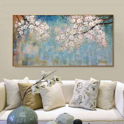 Living Room with Cherry Blossom Painting and Beige Sofa Abstract painting of cherry blossoms hanging above a beige sofa with floral cushions and a vase of flowers on the coffee table.
