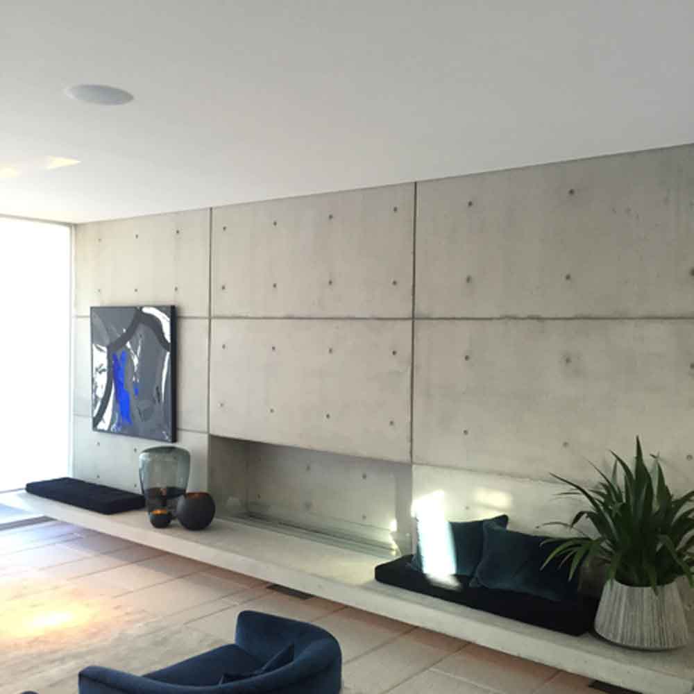 Modern living room with concrete walls, abstract art hung on picture rails, and minimalist decor featuring Artiteq products.