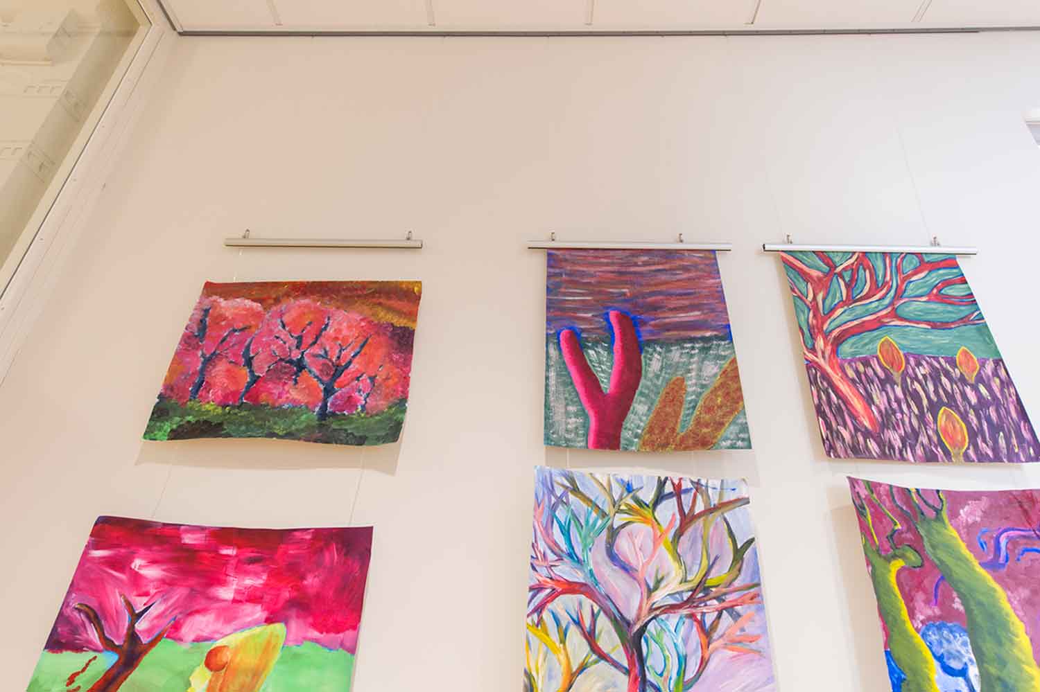 Colorful Artwork hanged on white wall. Colorful artwork hanging on a wall and hanging bars.