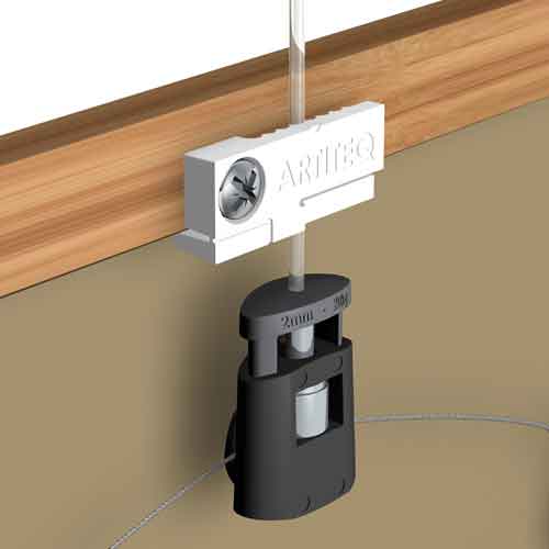 display of the use of tilt reducer pressing on a hanging wire with hooks attached behind the picture frame