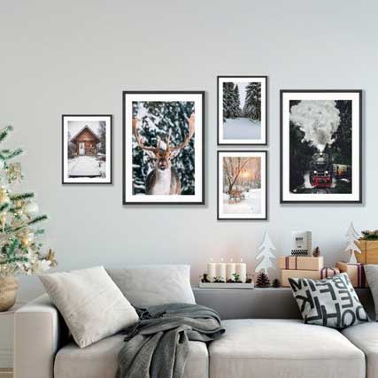 Framed posters on wall in a living room, showcasing a rotating gallery display with seasonal decor.