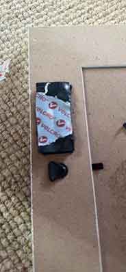 Close-up of Velcro adhesive applied to the back of a frame for hanging.