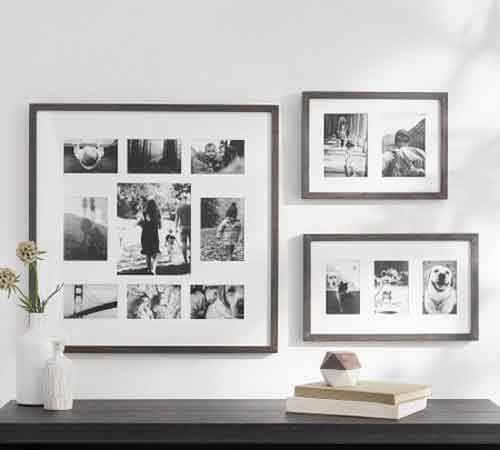Hang Photo Frames for Family Memories Three black and white photo frames hang on a white wall above a dark wooden shelf with decorative items