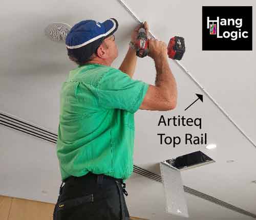 Hang Logic technician securing an Artiteq top rail to the ceiling at ECH Encore Apartments.
