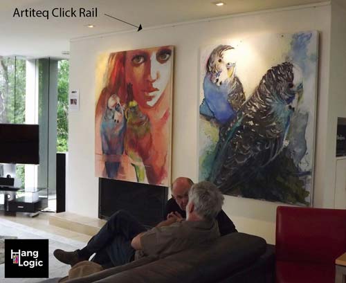 Custom picture rails showcasing a continuous, tailor-made Artiteq picture rail with large, vibrant artworks displayed in a living room.