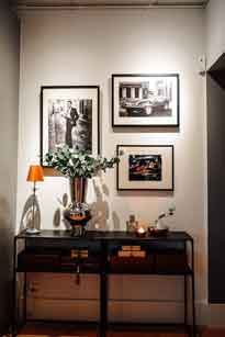 Elegant interior with a console table and three framed photos hung above using the Artiteq Click Rail Pro system, demonstrating how to hang photos securely and stylishly, available at Hang Logic.