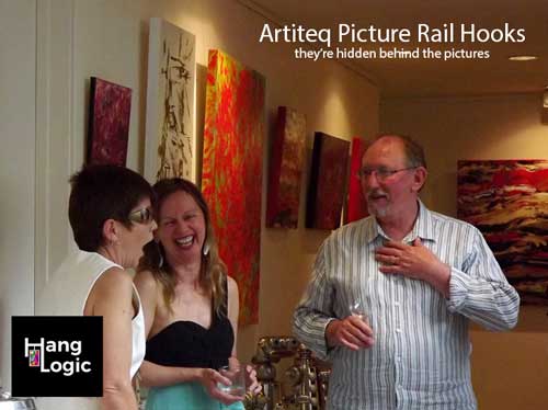 Artiteq picture rail hooks discreetly supporting artwork in a gallery setting, available at Hang Logic.