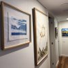 Framed artworks in hallway hung on wires from hidden ArtiTeq Shadowline Drywall picture rail