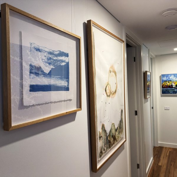 Framed artworks in hallway hung on wires from hidden ArtiTeq Shadowline Drywall picture rail