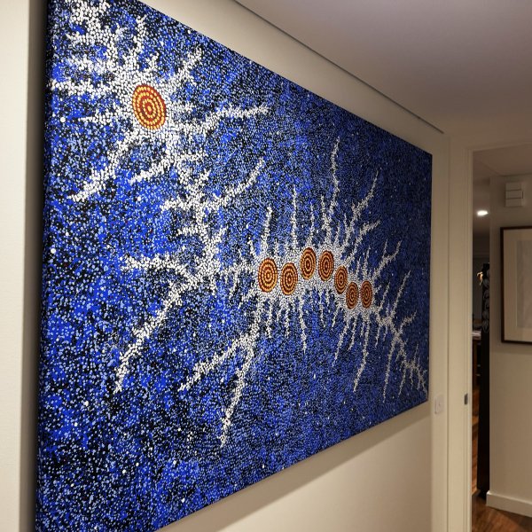 Large blue dot canvas hung on wires from hidden ArtiTeq Shadowline Drywall picture rail in hallway