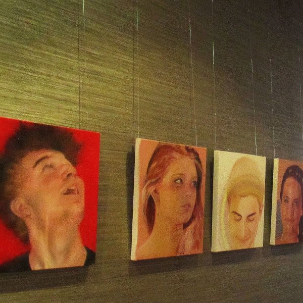 Hotel corridor displaying year‑12 student portraits hung on clear Slider Economy perlon wires, two cables per picture, supplied by Hang Logic.