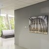 Large architectural canvas hung on clear wires from ArtiTeq Top Rail fixed to drop‑ceiling grid in modern office corridor